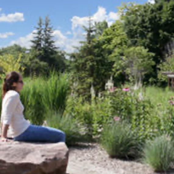 Woman sitting in building 30 nature garden.